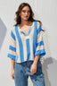 Woman wearing a blue and white striped sweater against a light background