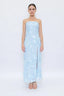 Woman wearing a light blue strapless dress with floral patterns on a white background