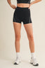 Person wearing black athletic shorts on a beige background