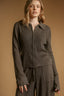 Woman wearing a brown ribbed knit outfit against a beige background