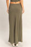 Person wearing a green ribbed maxi skirt on a plain background
