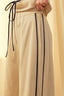 Beige pants with black stripes and drawstring on a light background