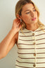 Woman wearing a striped dress with buttons against a plain background