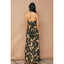 Woman wearing a floral strapless dress against a beige wall.