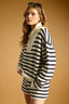 Woman wearing a black and white striped sweater against a beige background