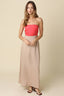 Woman wearing a red strapless top and beige skirt on a beige background