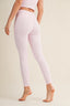 Person wearing light pink leggings on a plain background