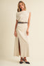 Three-quarter front view of the Soleil Cowl Neck Belted Maxi Dress in cream, showcasing the full-length column silhouette, asymmetrical cowl neckline, belted waist, and high side slit revealing movement in the floor-grazing hem