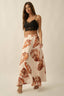 Woman wearing a black lace top and a long skirt with shell pattern on a beige background
