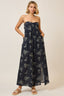 Woman wearing a strapless floral dress on a plain background