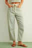 Person wearing light blue and white striped pants with a plain background