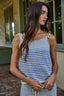 Woman wearing a blue and white striped tank top standing outdoors.