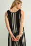 Woman wearing a black and white striped dress with a plain background