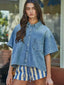 Woman wearing a denim shirt and striped shorts outdoors