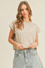 Woman wearing a beige t-shirt and light blue jeans against a plain background