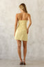 Woman wearing a yellow dress against a plain background
