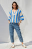 Woman wearing a striped sweater and jeans against a white background