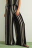 Person wearing a black and white striped jumpsuit on a plain background
