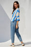 Woman wearing a striped sweater and jeans against a white background