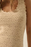 Close-up of a beige crochet dress on a plain background