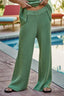 Person wearing green knitted pants by a poolside