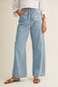 Light blue jeans worn by a person on a beige background