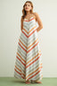 Woman wearing a long, striped dress with vertical orange and beige stripes on a plain background