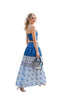 Woman in a blue and white dress standing outdoors with people in the background