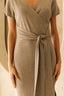 Brown wrap dress with a tie waist on a neutral background