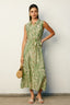 Woman wearing a green and white patterned dress against a plain background