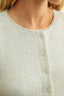 Close-up of a light green ribbed sweater with button details