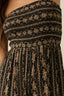 Close-up of a textured black and gold dress with a patterned design.