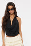Woman wearing a black sleeveless top and white skirt on a plain background