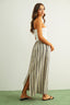 Woman wearing a white top and striped skirt on a plain background