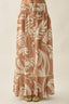 Long floral skirt with a pattern of white flowers and leaves on a beige background