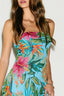 Woman wearing a colorful floral dress with a plain background