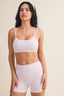 Woman wearing a white checkered sports bra and shorts set on a beige background