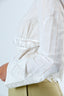 Woman wearing a white lace top with a plain background
