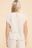 Woman wearing a beige ribbed top and pants on a beige background