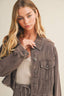 Woman wearing a brown denim jacket on a beige background