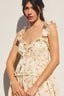Woman wearing a floral dress against a plain background