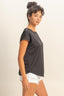 Woman wearing a black t-shirt and white shorts on a beige background