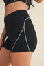 Black athletic shorts with white accents worn by a person on a neutral background