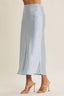 Light blue satin skirt worn by a person on a beige background