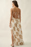 Woman wearing a floral dress with an open back on a plain background