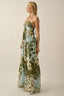 Woman wearing a floral maxi dress on a plain background