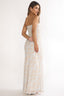 Woman wearing a strapless, patterned gown on a white background