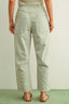 Person wearing light blue and white striped pants on a light background