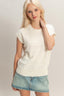 Woman wearing a white sweater and denim skirt on a plain background