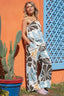 Woman in a floral dress standing in front of an orange wall with a blue patterned section.